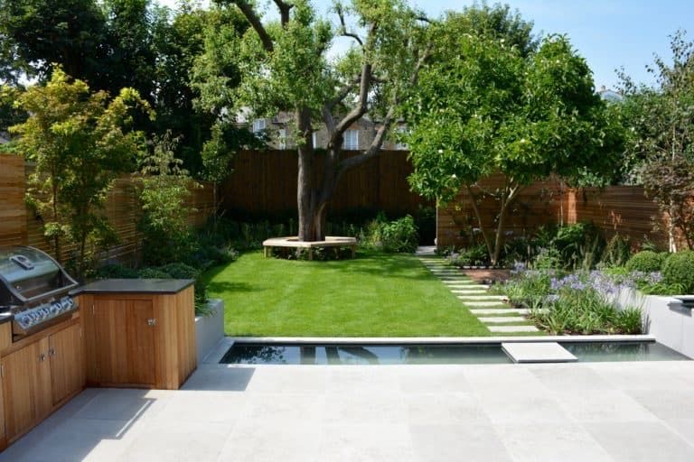 Garden room behind a lawn with a stepping-stone path