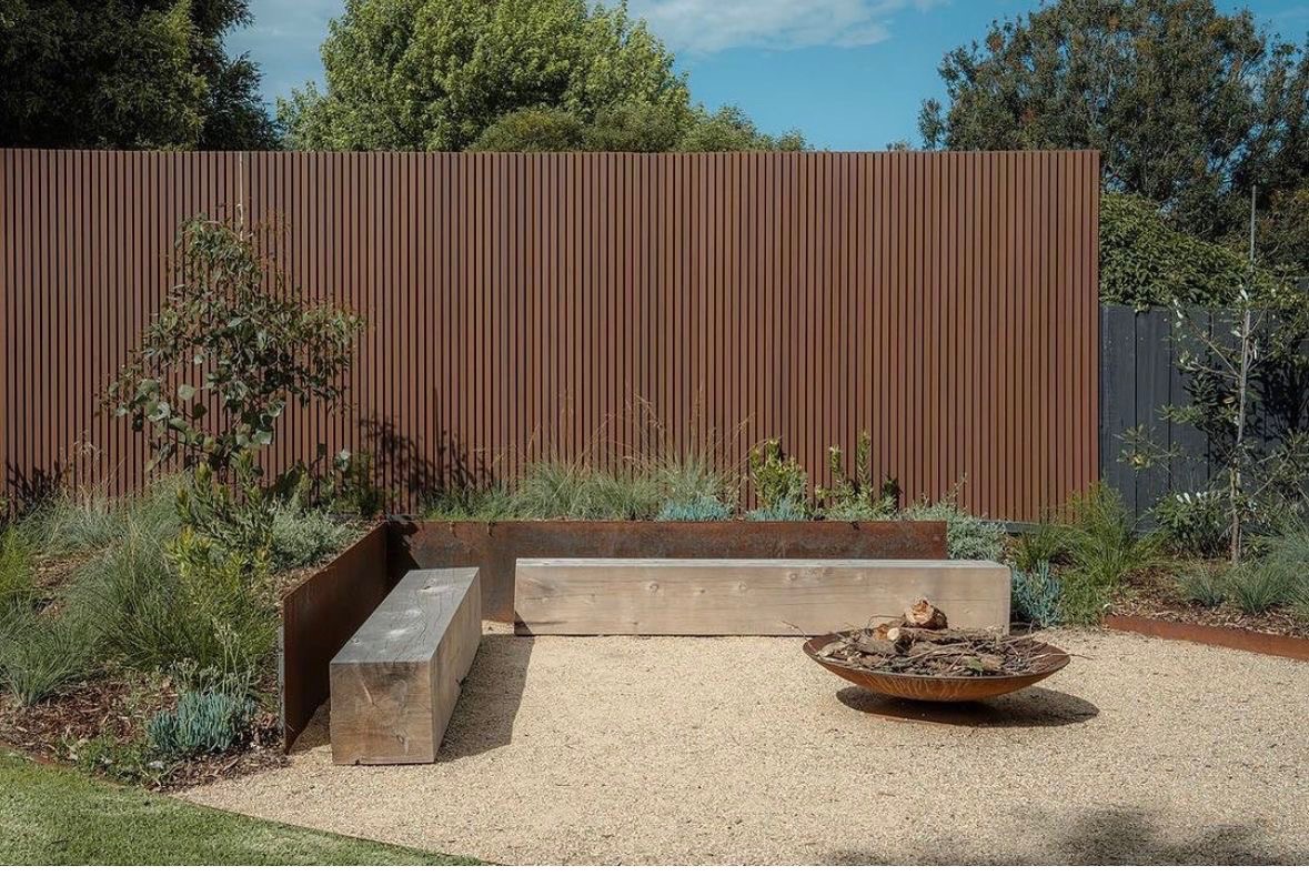 Timber bench with corten backing and fire bowl