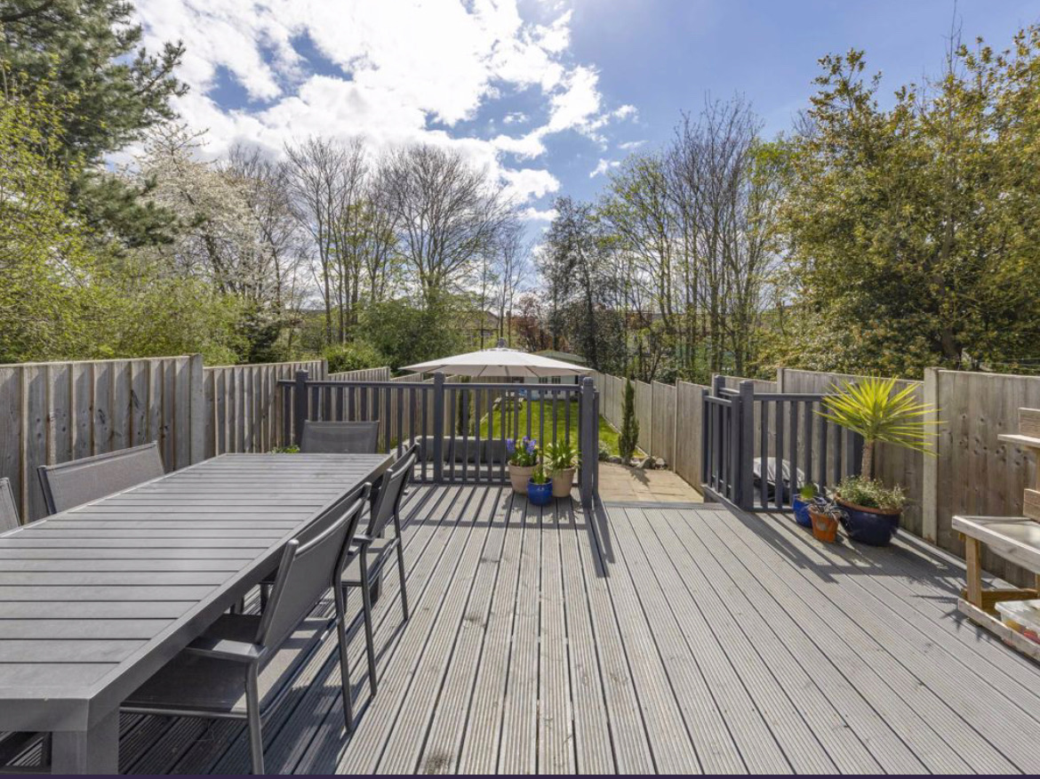 Existing deck with dining table looking down the garden