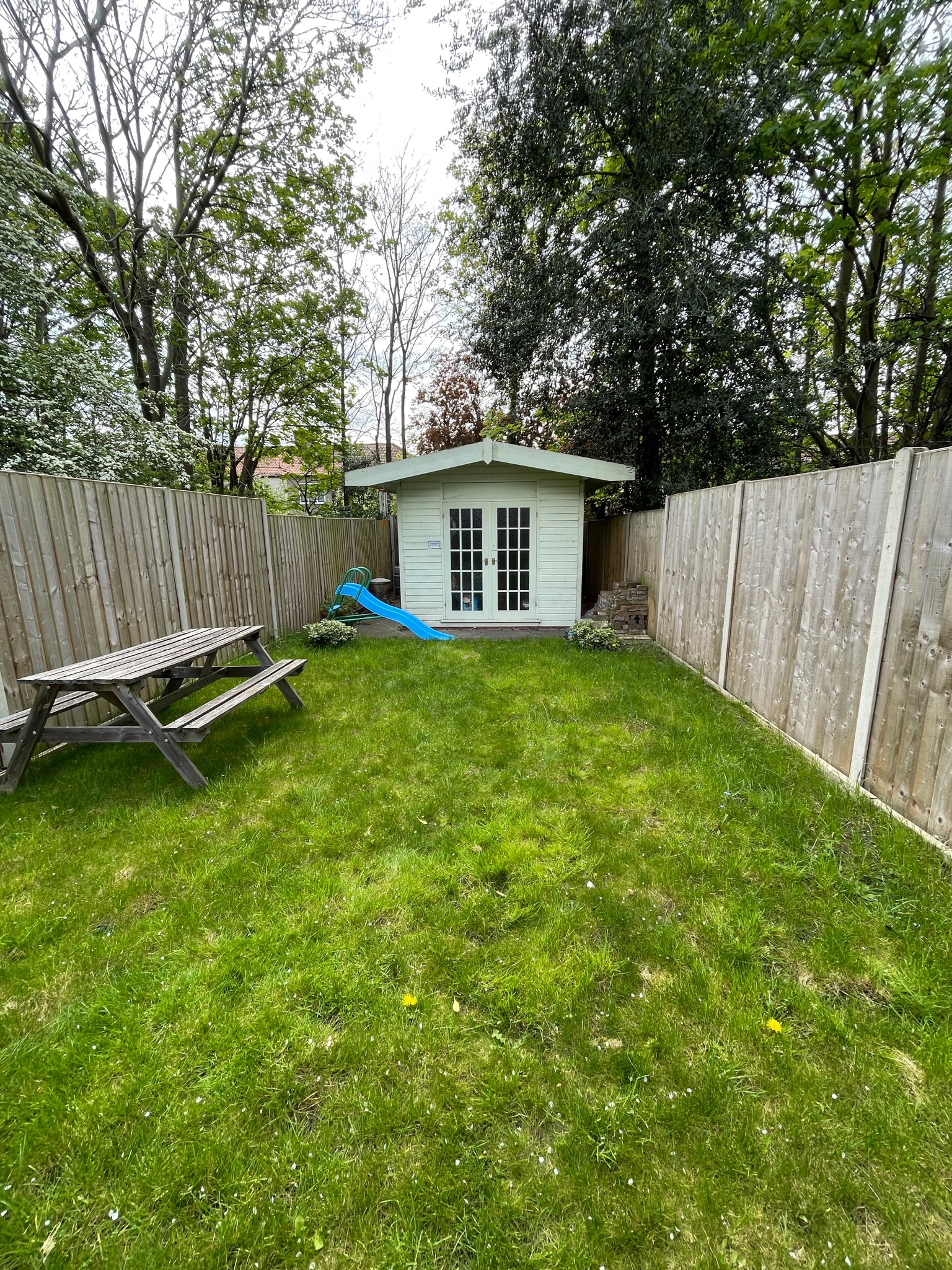 Existing lawn with picnic bench, slide and summer house