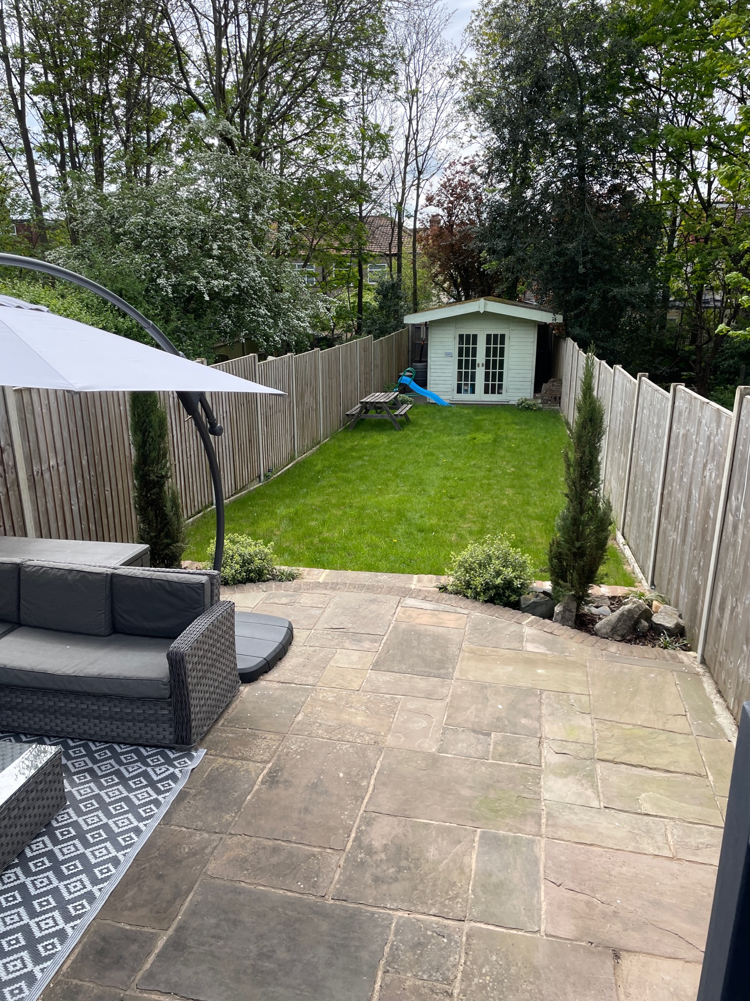 Existing lawn and shed viewed past the patio umbrella