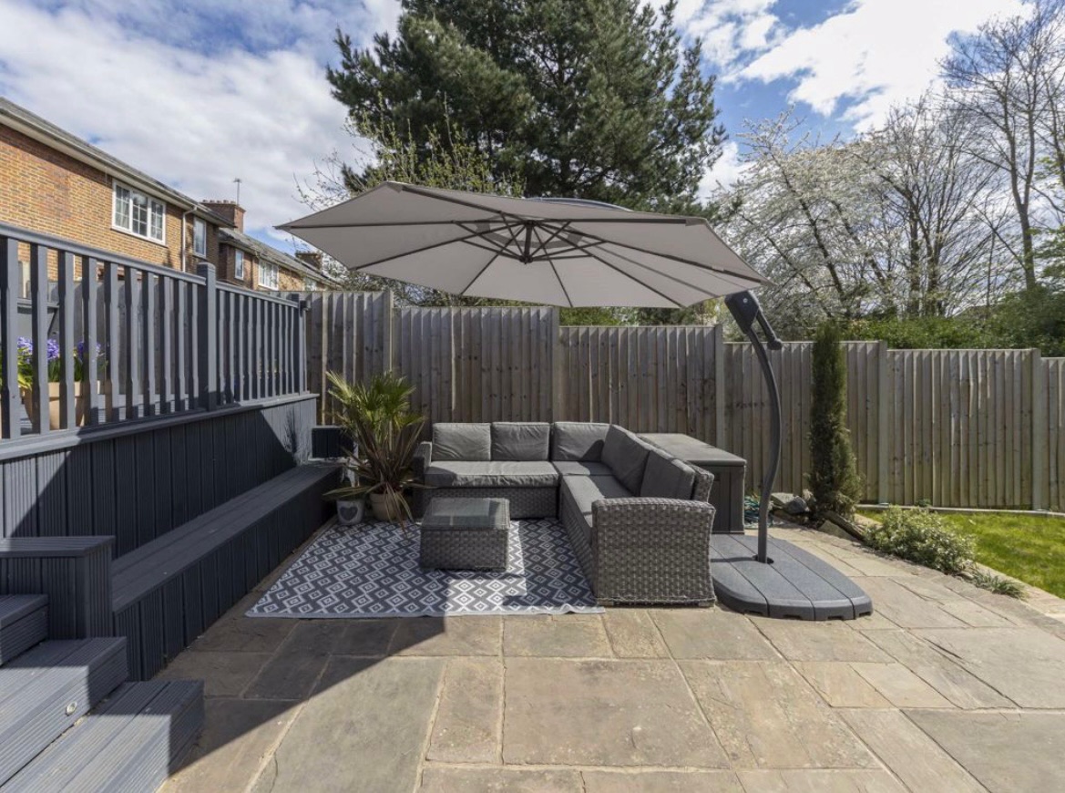 Existing patio with rattan sofa and umbrella